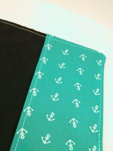 Vue de détail des ancres du protège carnet de santé ancres blanches sur fond turquoise