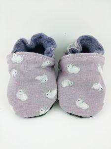 Paire de chaussons souples bébés en tissu mauve avec des petits lapins blancs