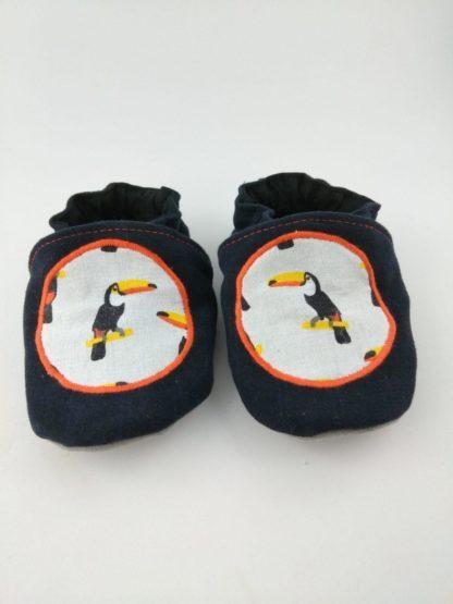 Paire de chaussons souples bébé avec motif toucan et liseré orange