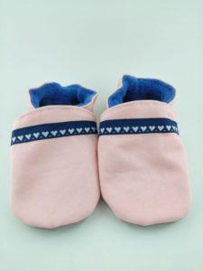 paire de chaussons souples bébé personnalisés avec tissu rose et cœurs blanc sur bande bleue